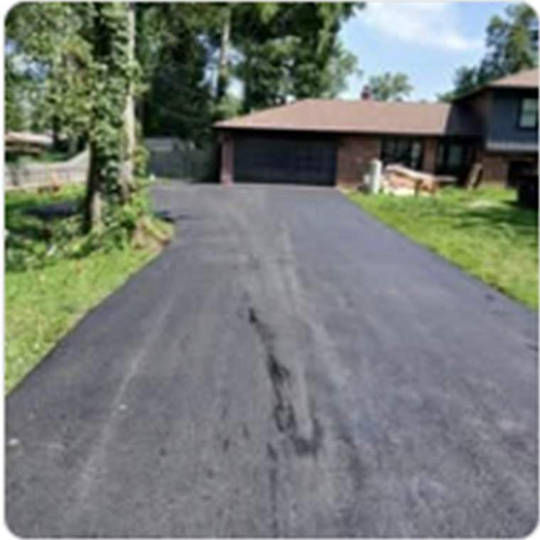 Newly surfaced driveway leading to a home and garage